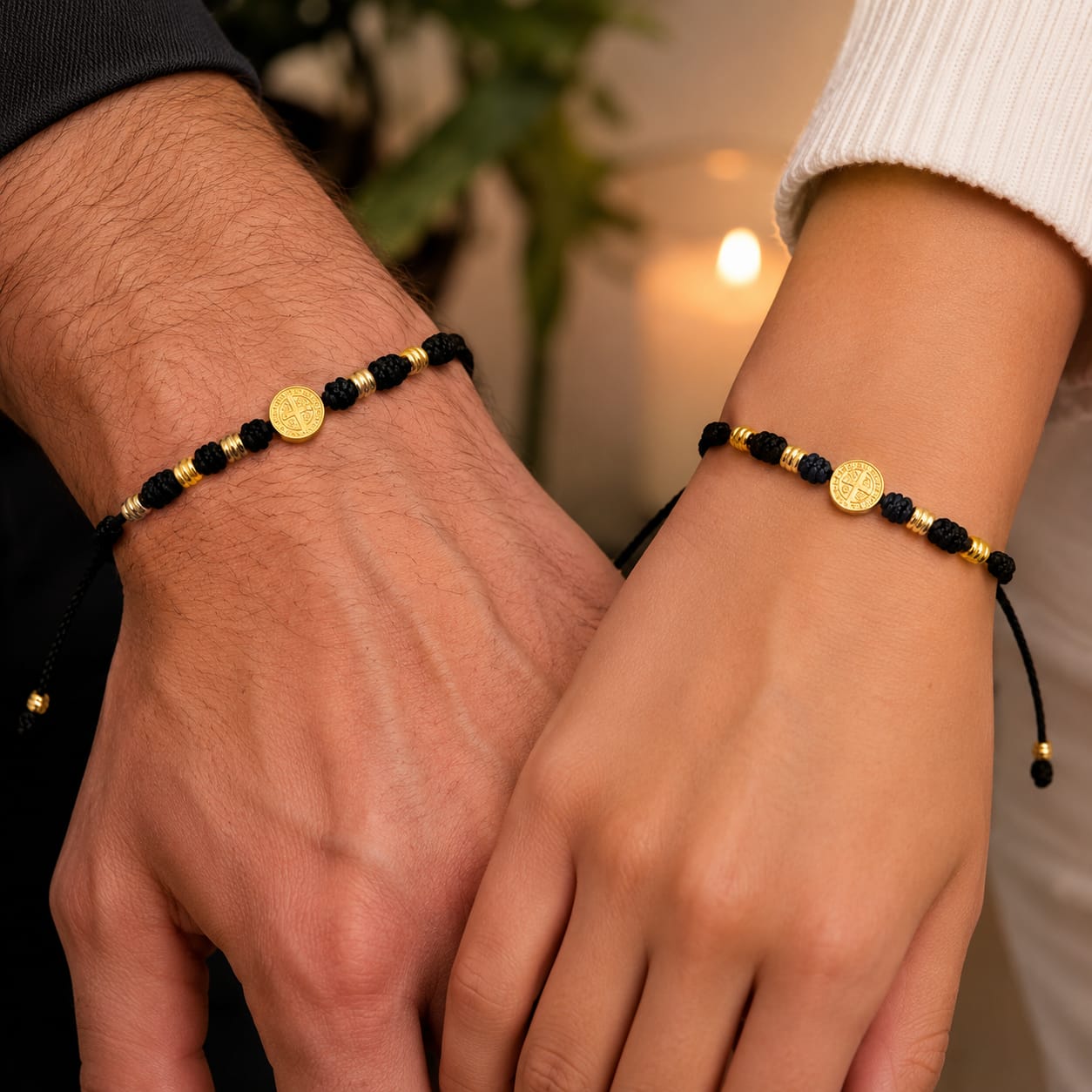 Pulseras negras con medalla de San Benito puestas en dos muñecas